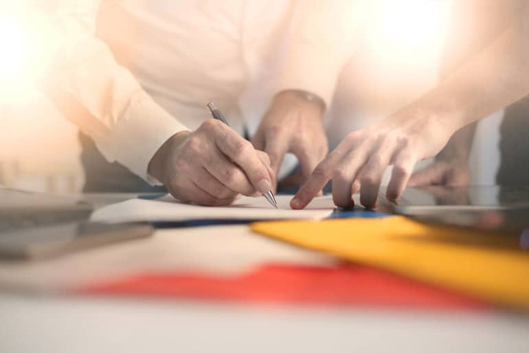 Two business people review signing a contract