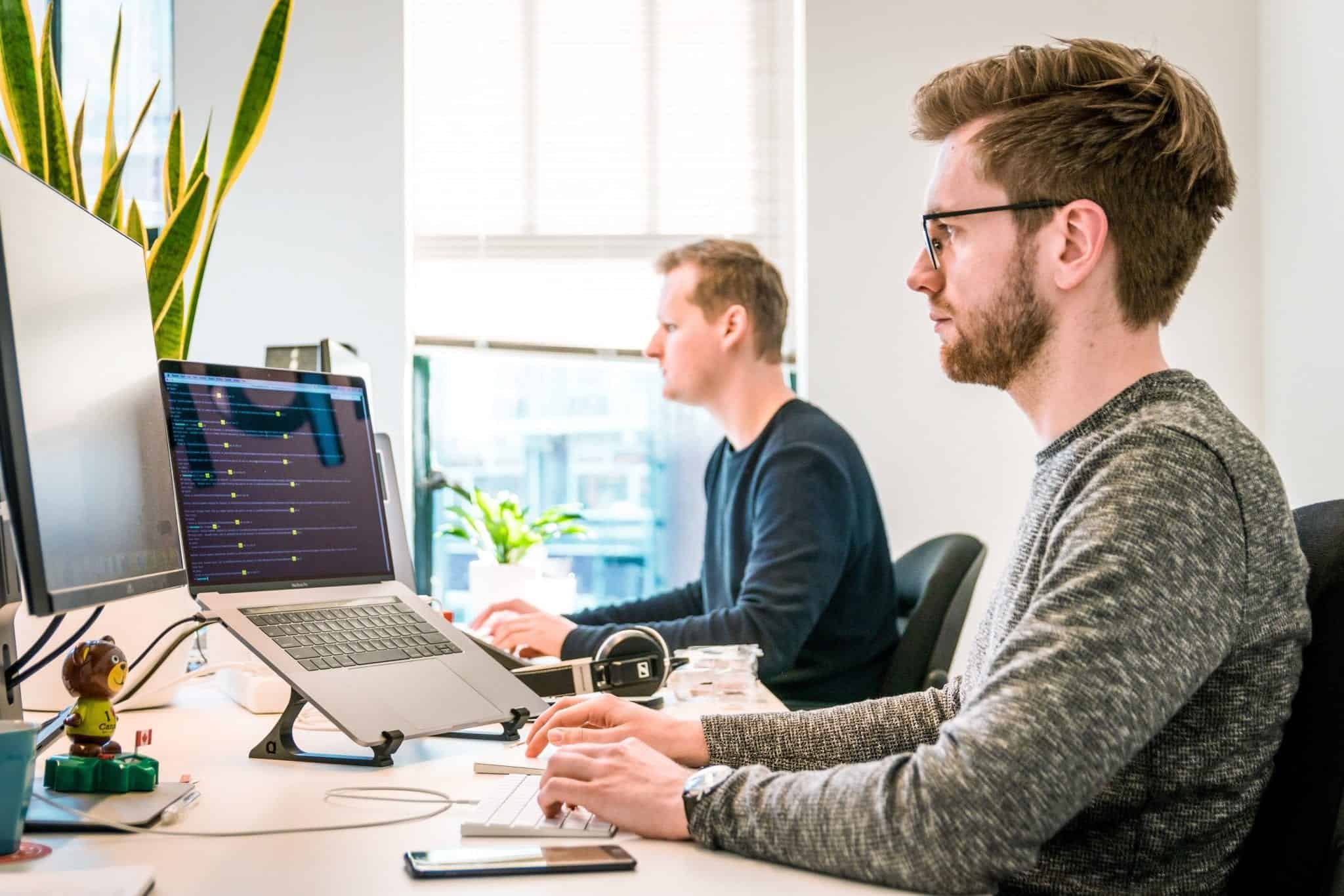 Two men working on their computer from their desk