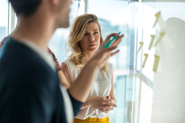 Two business people work on their agile approach on project at white board