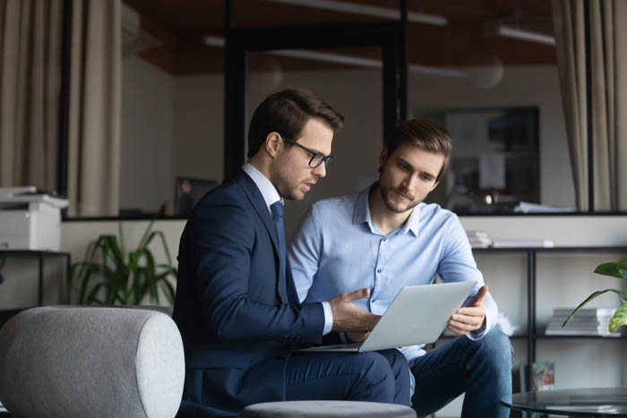 Coworkers seated at computer discussing project management and law