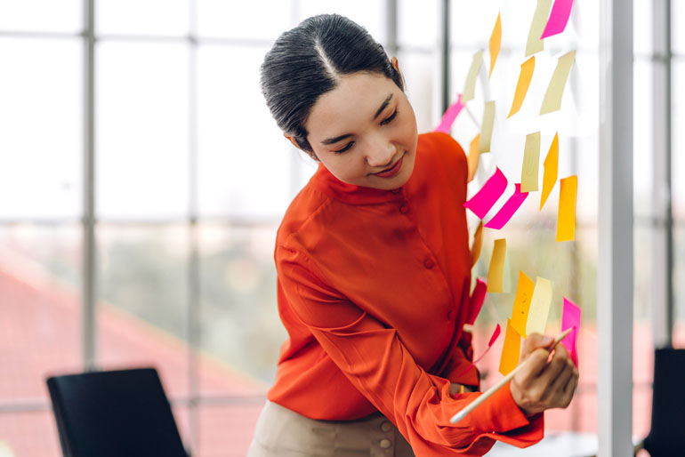 Woman at whiteboard working on project