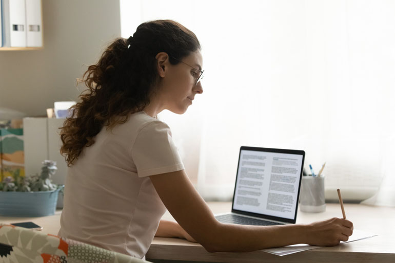 Woman gathering information about the PMP exam 2023 at her desk on her computer