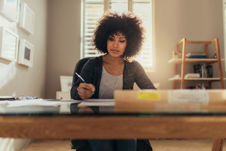 Woman at her desk preparing to study for the PMP exam.