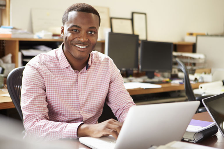 Male professional reviewing the CAPM exam format and content from his laptop.