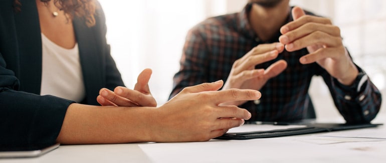 Close up of two business people talking about project management methodologies