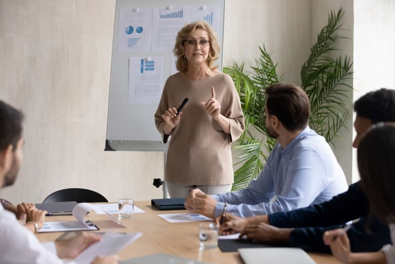 Business woman standing as she leads a meeting