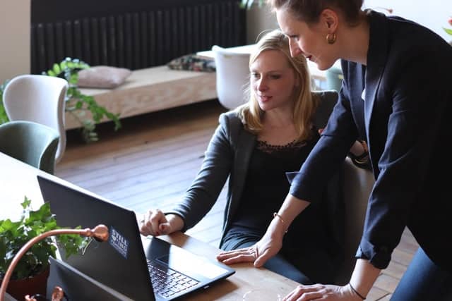 Two business women working on a project charter on the computer