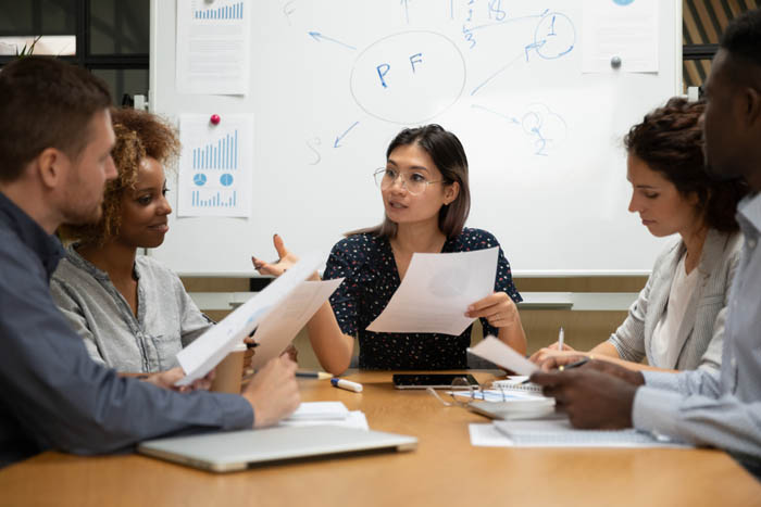 Small team sitting in a conference room managing project communications.